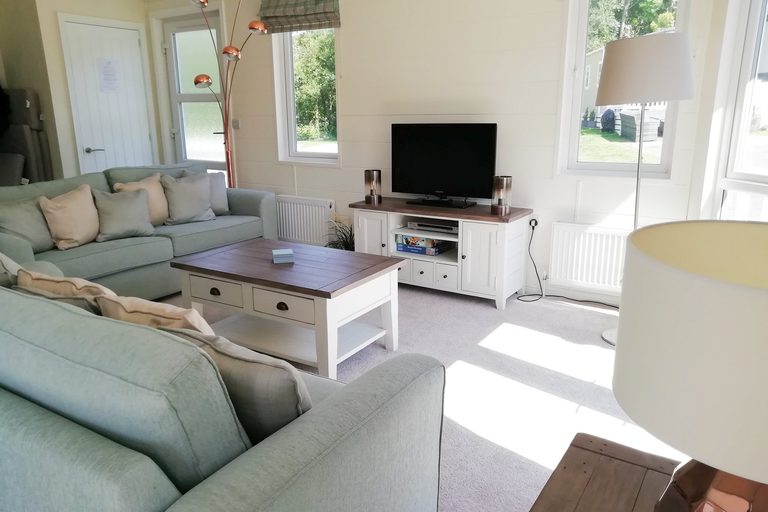 Cosy living area with sofa and TV at Mo's Keep, Shorefield Country Park