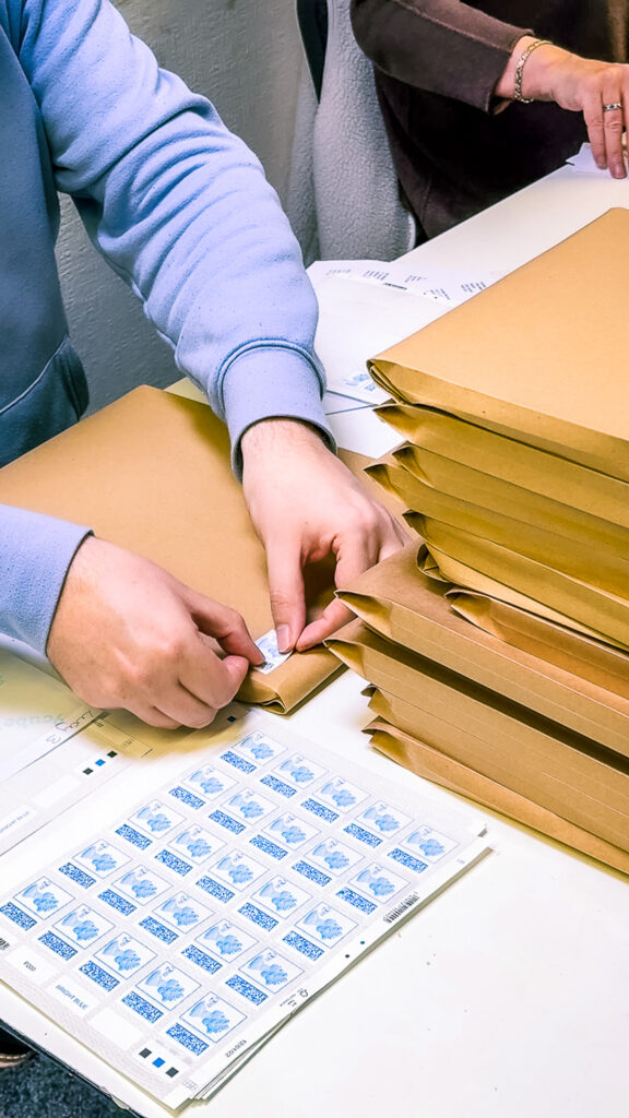 A volunteer's hands packaging treats for children in the Momentum office.