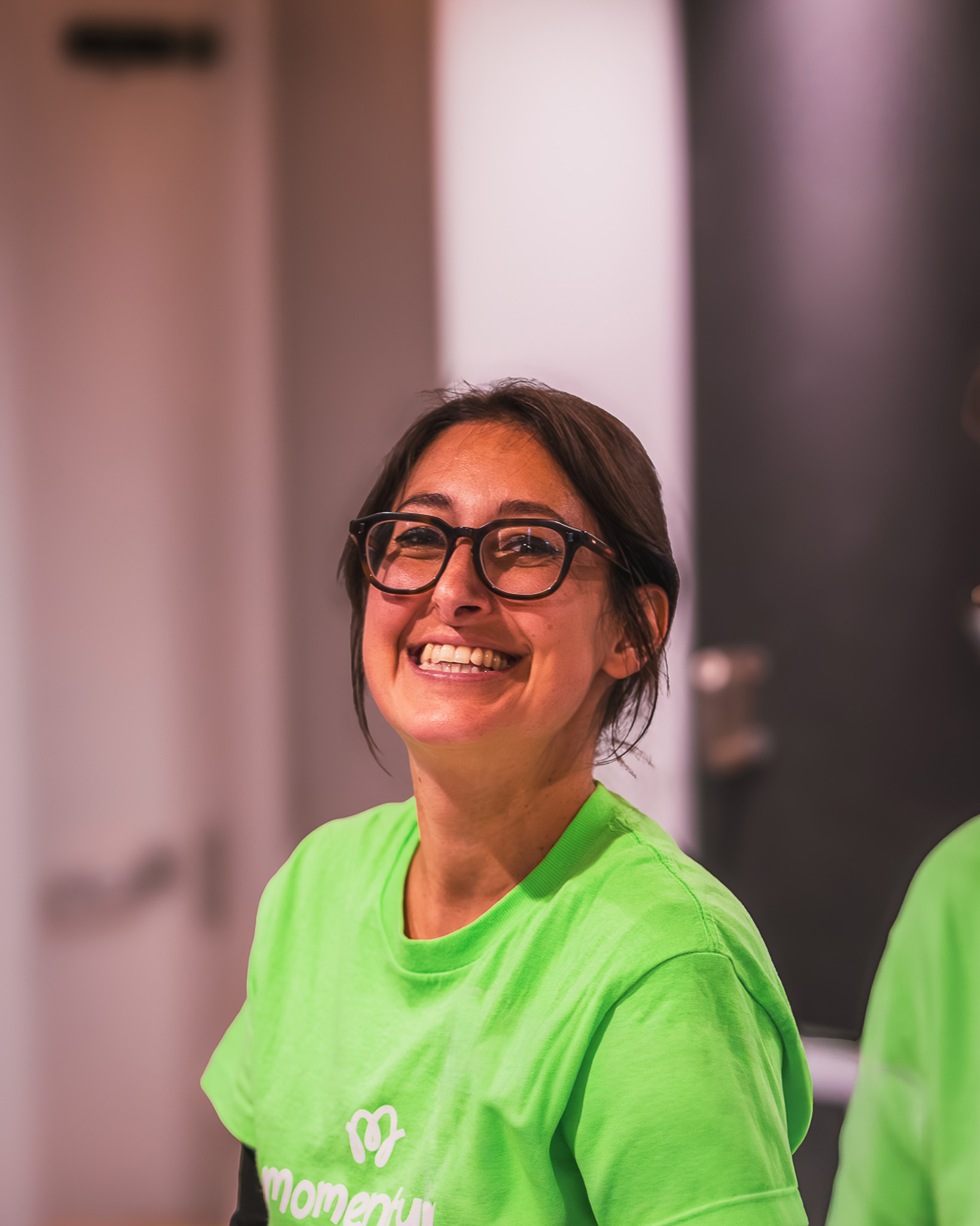 A Momentum team member smiling at the camera at the charity's annual Comedy Night event.