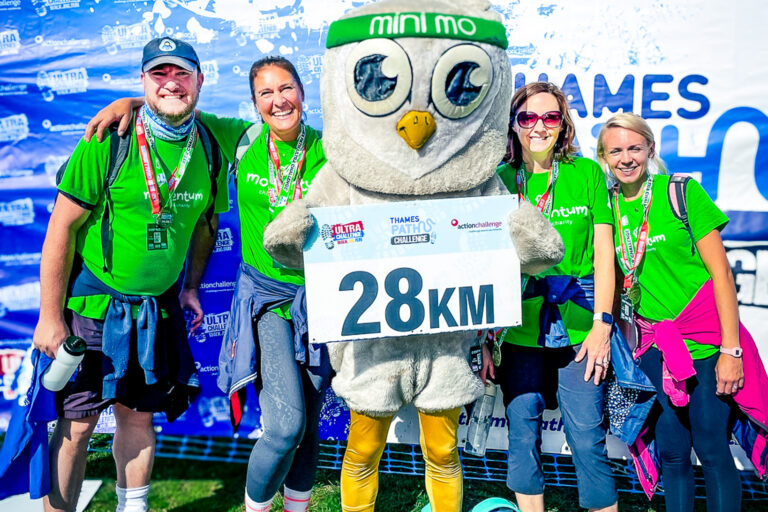 The Echoes team and two supported parents celebrating completion of the Thames Path challenge for Move for Momentum, posing with medals alongside Mo the mascot.