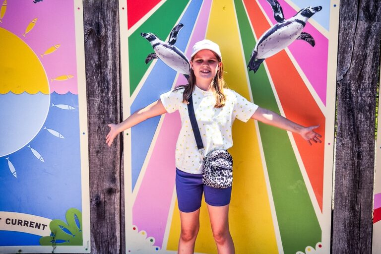 A sibling supported through Momentum's Echoes programme posing with arms stretched wide at London Zoo.