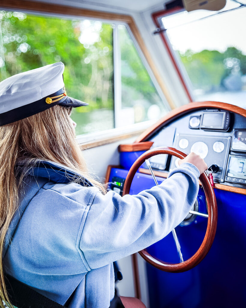 A child supported by Momentum driving the boat.