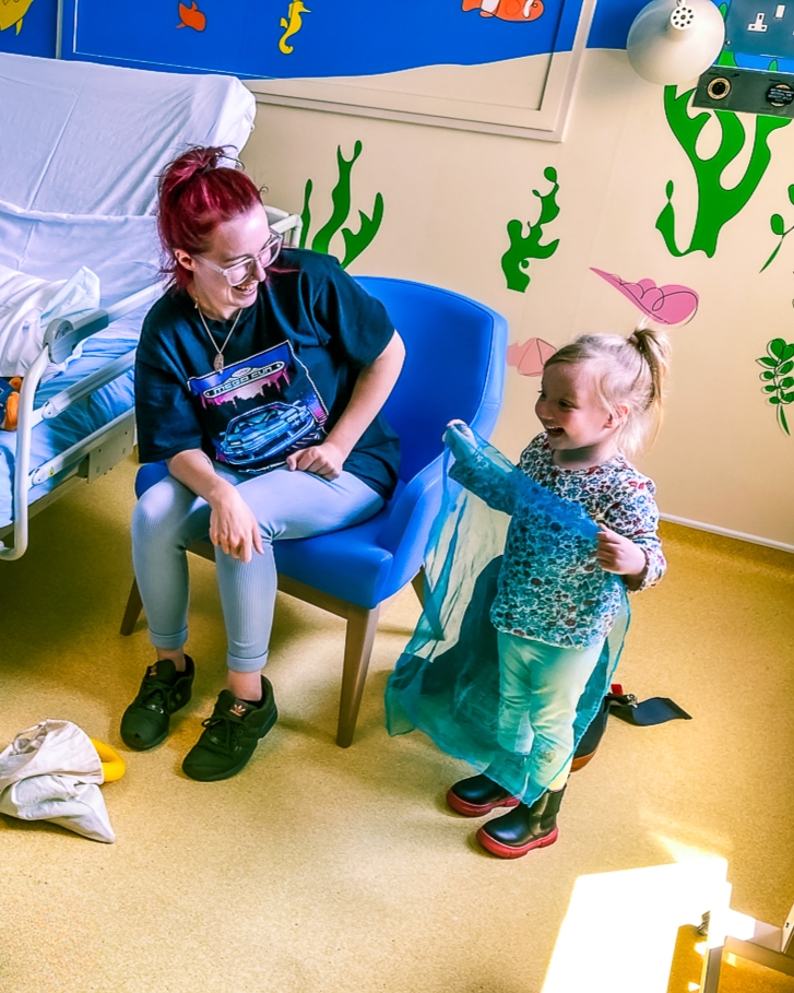 A supported child receiving music therapy at hospital.