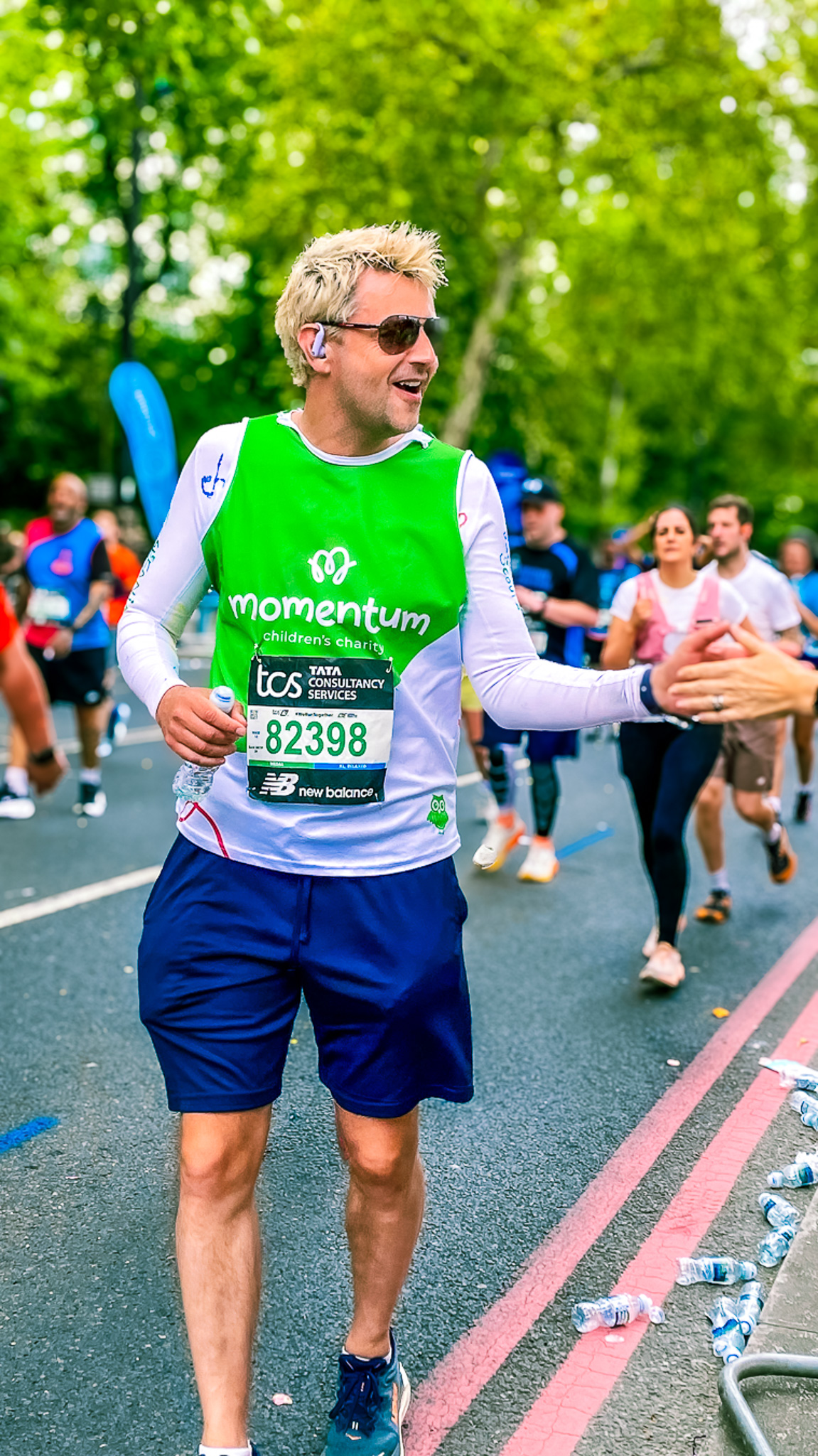 A runner high-fiving Momentum's cheer squad as he passes during the London Marathon.