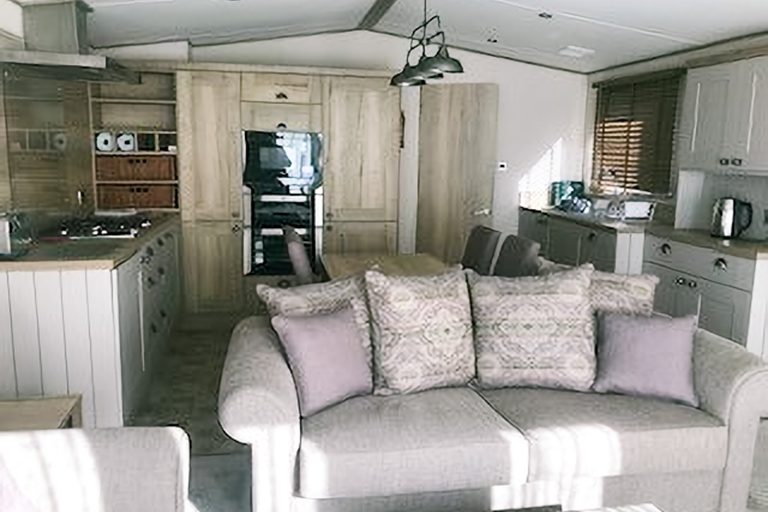 Open-plan living room and kitchen inside Momentum Children's Charity respite cabin at Church Farm Holiday Village.