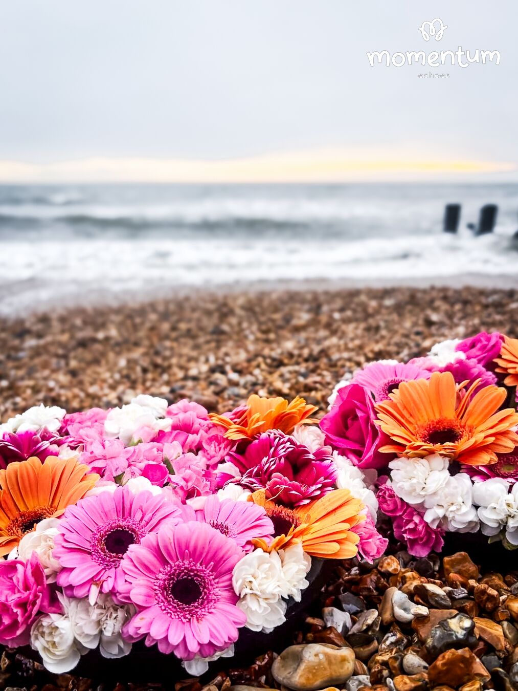 Flower wreaths laid on the beach in memory of a child supported by Momentum's Echoes programme who died.