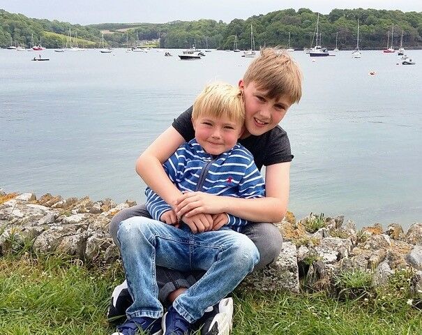 A child supported through Momentum's Echoes programme hugging their brother, who has died, pictured together on a family holiday by the sea.