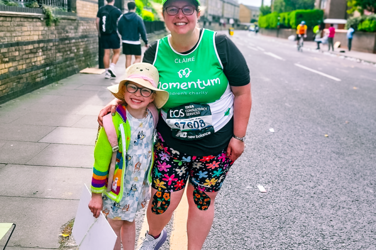 A young girl in a hat and a woman wearing a Momentum Children's Charity running vest pose at The London Marathon