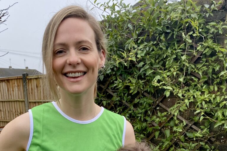 A Momentum fundraiser wearing a Momentum branded running top, and her young daughter.