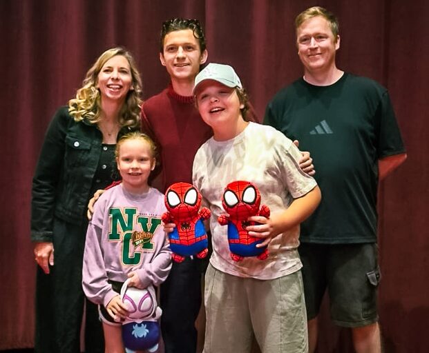 A Momentum-supported family with Tom Holland at the Spiderman screening. A boy holds two spiderman dolls.