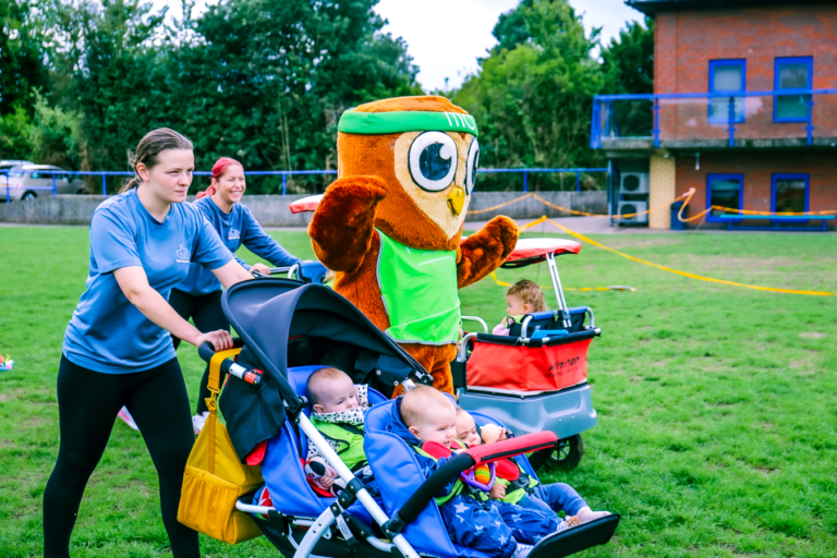 Nursery staff and children in buggies take part in Move for Momentum