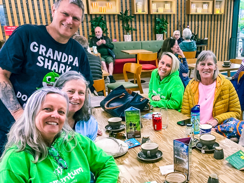 A group of Grandparents gather around a table with two of Momentum's Family Support Workers during a walk and talk at Wakehurst.