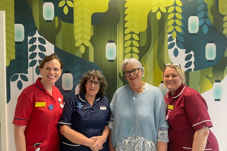 Momentum Founder stands with three members of staff in the paediatric oncology ward at Kingston Hospital.