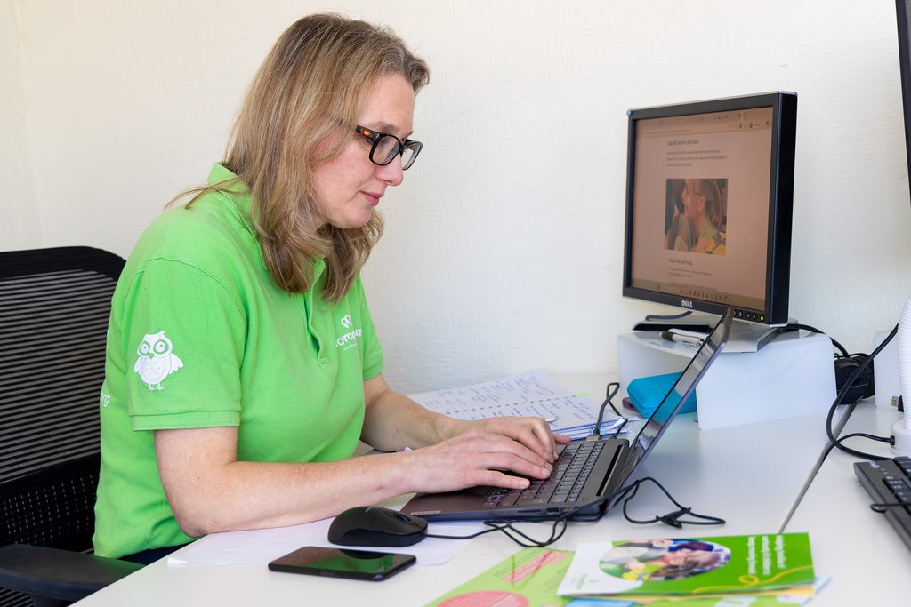 Momentum social worker sits at a desk in the office working.