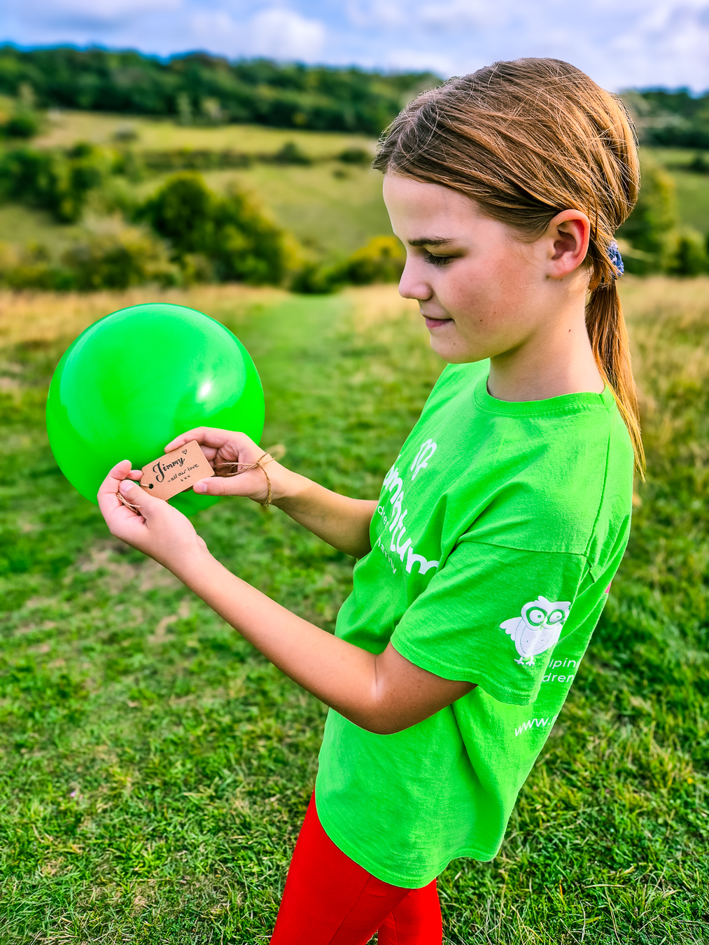A Momentum Young Ambassador reads a message on a green balloon