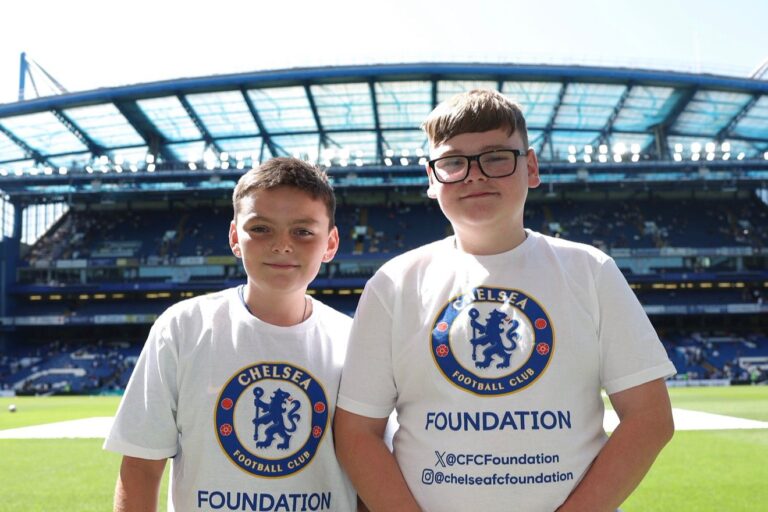 Two brothers wear their Chelsea FC shirts as they visit the famous football stadium.