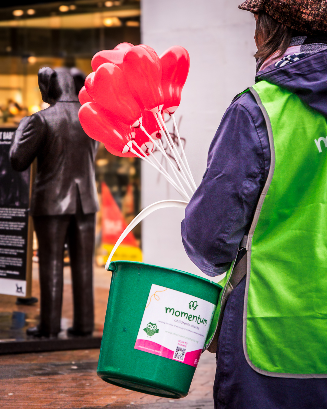The back of a collection bucket as a Momentum volunteers sells heart shaped balloons to help raise money for Momentum.