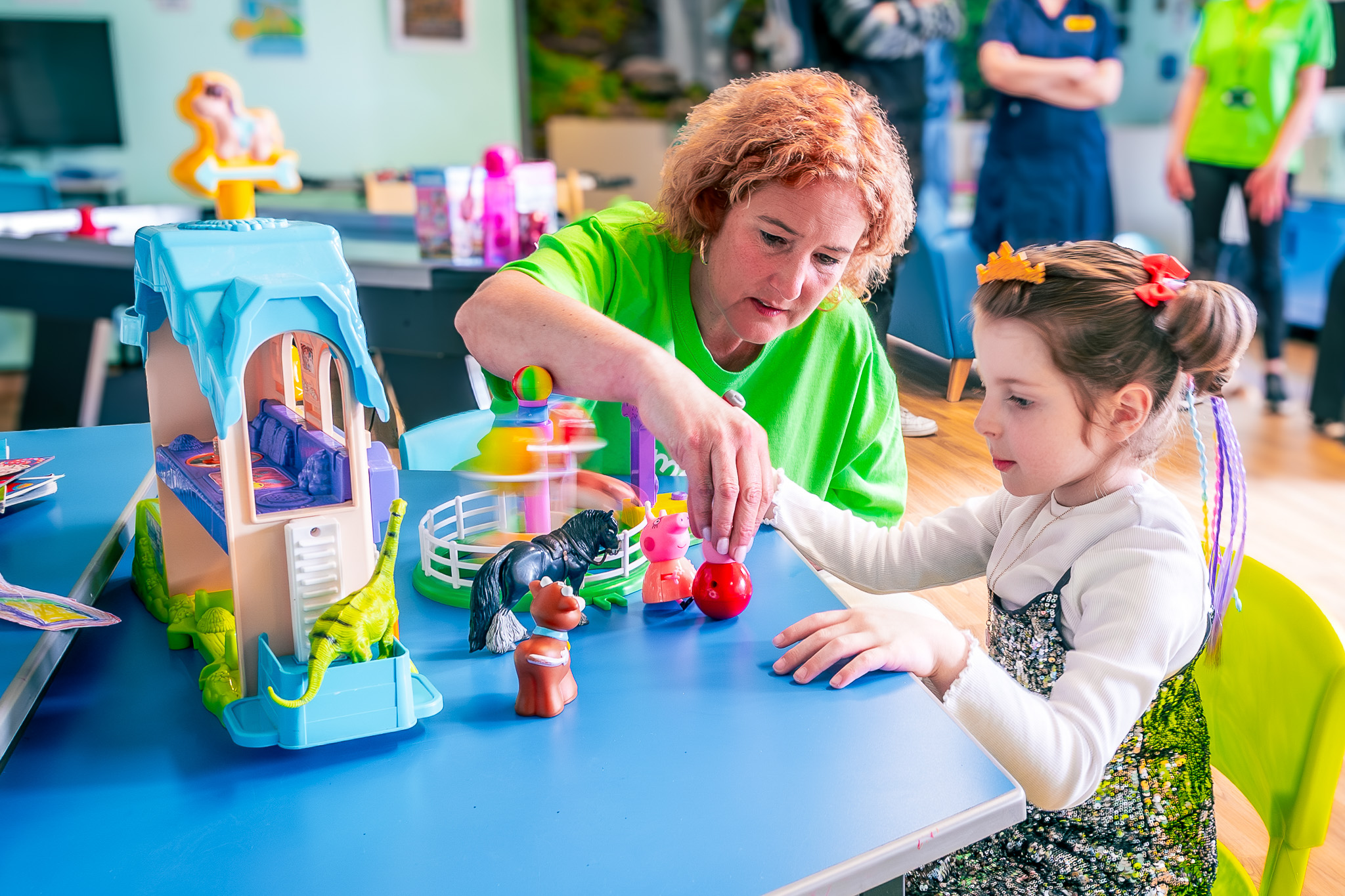 A supported child plays with toys with a Momentum staff member.