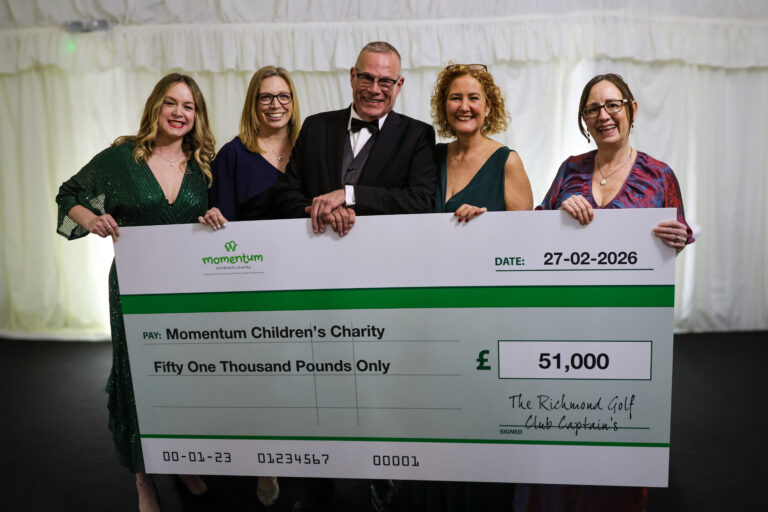 Momentum team members smiling broadly, together with Richmond Golf Club Captain, behind a giant cheque.
