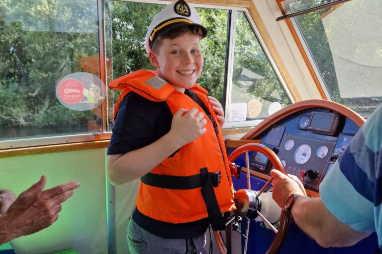 Momentum Young Ambassador at the helm of Momentum's river boat