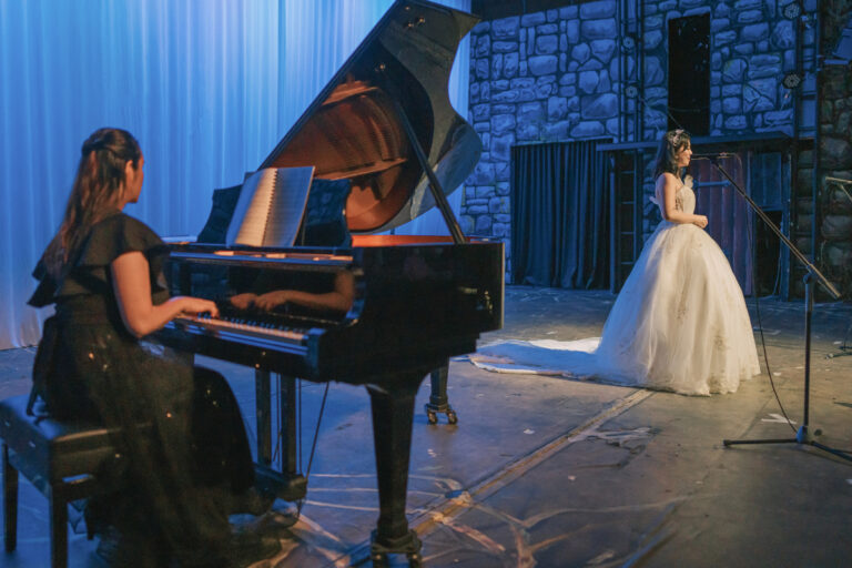 An opera singer and pianist on stage performing