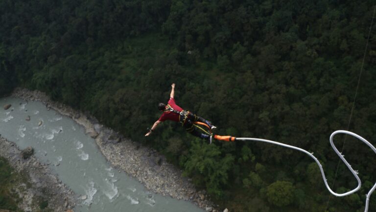 Man bungee jumping above a large canyon.