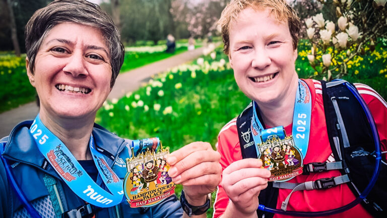 Runners hold up their medals after running the Hampton Court half marathon for Momentum Children's Charity