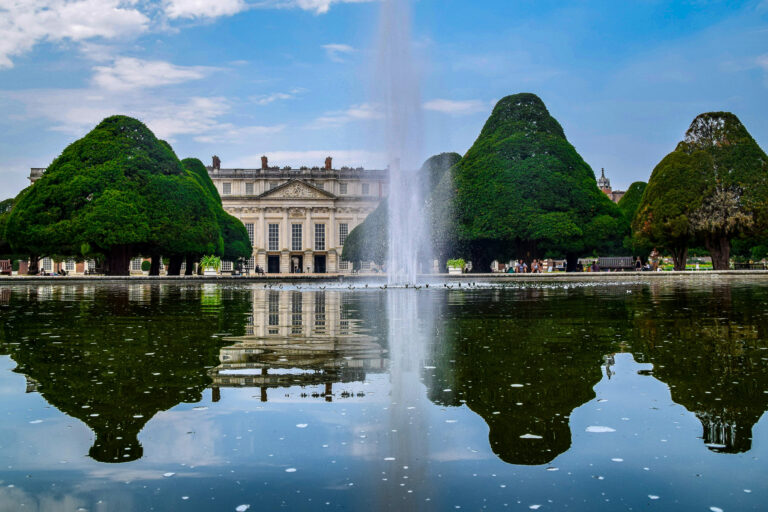 Hampton Court Palace stands beyond its expansive lawns and neatly trimmed topiary, showing the historic setting of this charity challenge event.