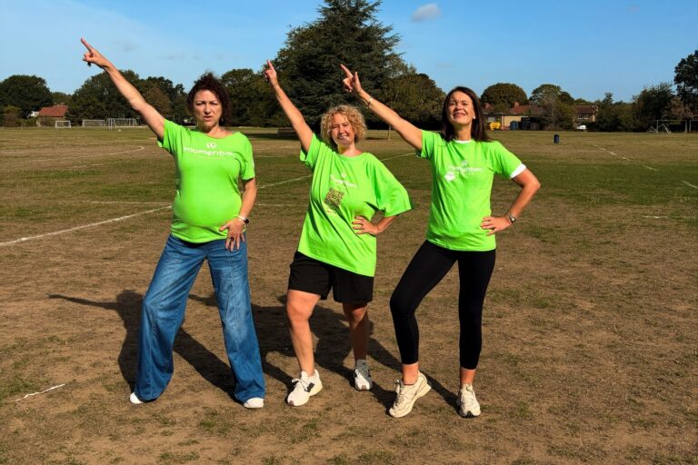 Momentum CEO and participants dancing in a field wearing green momentum tshirts