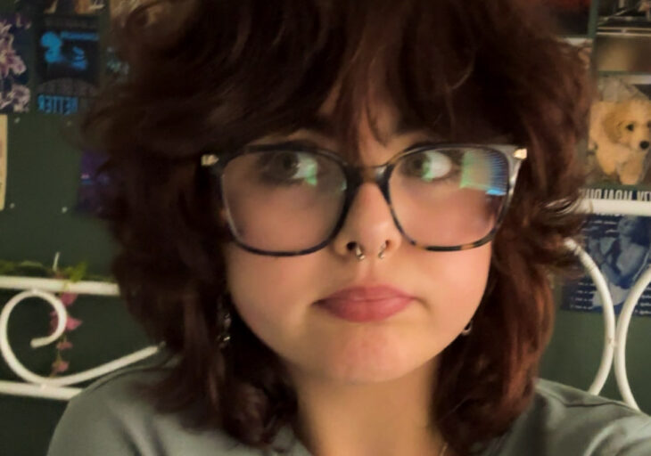 A Momentum Young Ambassador in glasses and dark curly hair with a nose piercing.